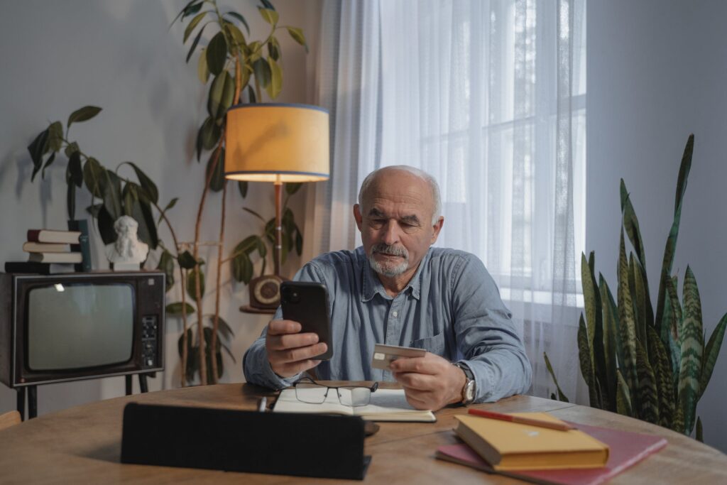 Man Holding A Smartphone & A Credit Card