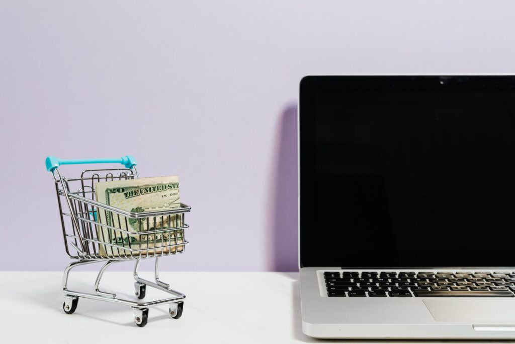 Shopping Cart Next To An Open Laptop